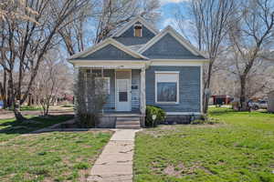 View of front of property with a front lawn and covered porch