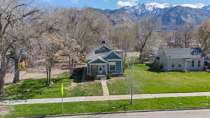 View of front of house with a front lawn and a mountain view
