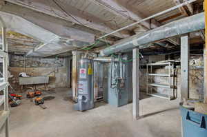 Unfinished below grade area with gas water heater and heating unit