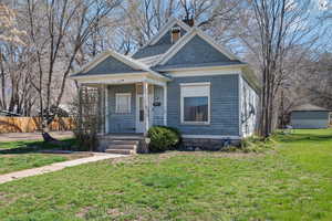 View of front of property featuring a chimney and covered porch
