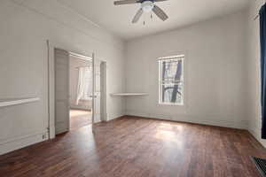 Spare room featuring dark wood-style floors and a ceiling fan