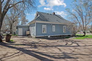 Back of property with roof with shingles, a chimney, and a patio area