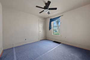 Spare room with a textured ceiling, carpet, and ceiling fan