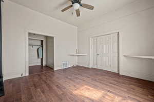 Unfurnished bedroom featuring dark wood-type flooring, a ceiling fan, a closet, and lofted ceiling