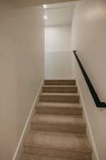 Stairway with baseboards and recessed lighting