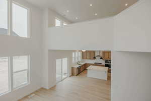 Kitchen with light countertops, light wood-style flooring, a center island, recessed lighting, and wood finish cabinets