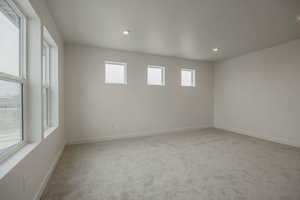 Spare room featuring light colored carpet and recessed lighting