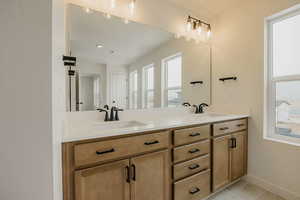 Bathroom with double vanity and light tile patterned floors