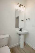 Bathroom featuring baseboards and light wood finished floors