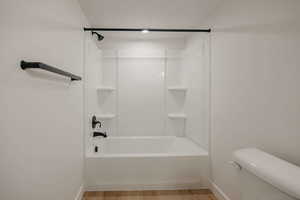 Bathroom with light wood-style floors and tub / shower combination