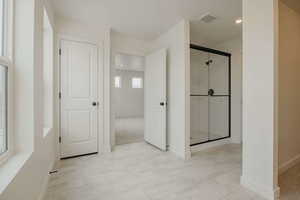 Full bath with a shower stall, recessed lighting, and light tile patterned floors