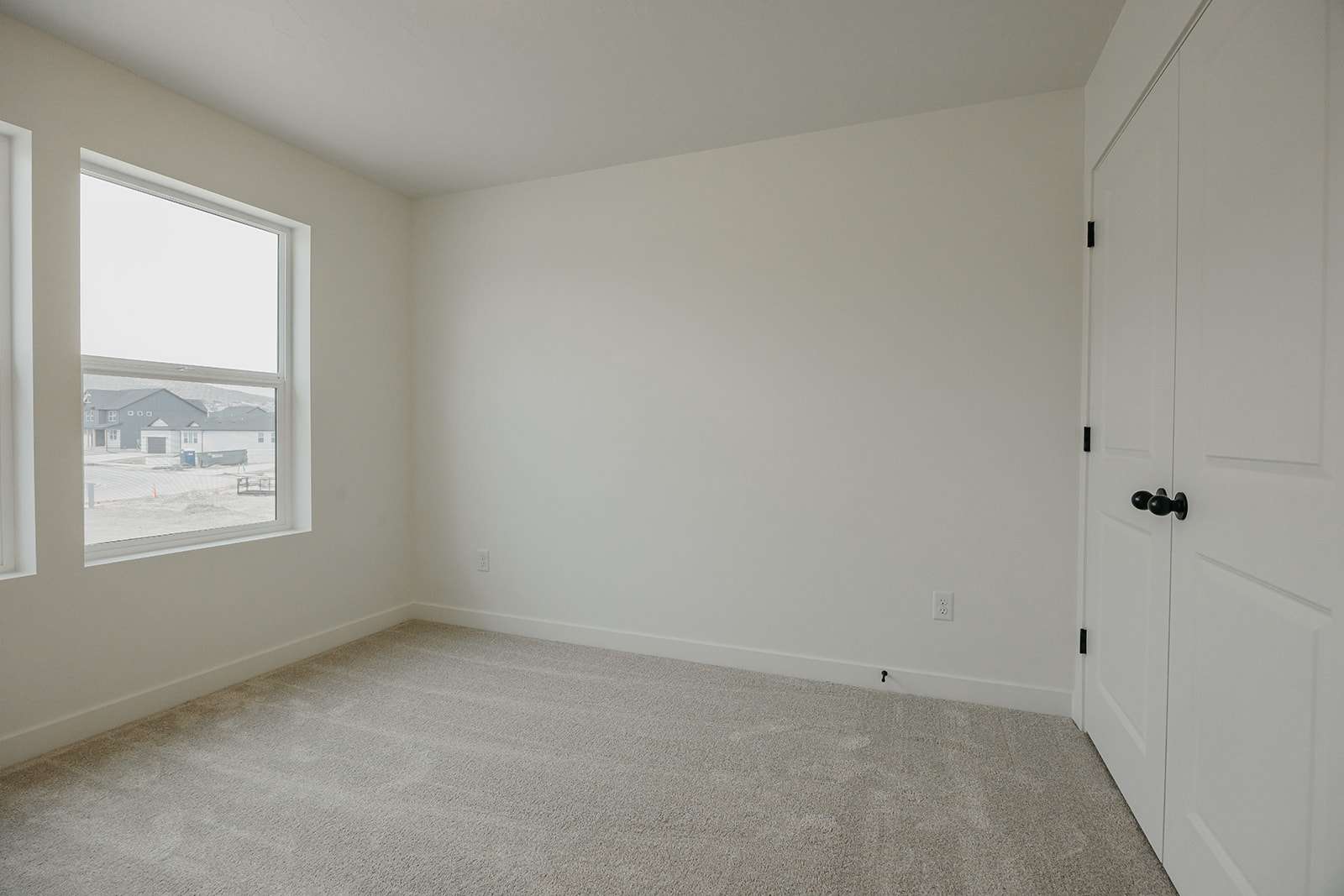 Unfurnished bedroom with light colored carpet and a closet