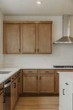 Kitchen featuring two tone cabinets, light stone counters, recessed lighting, light wood-type flooring, and dishwasher