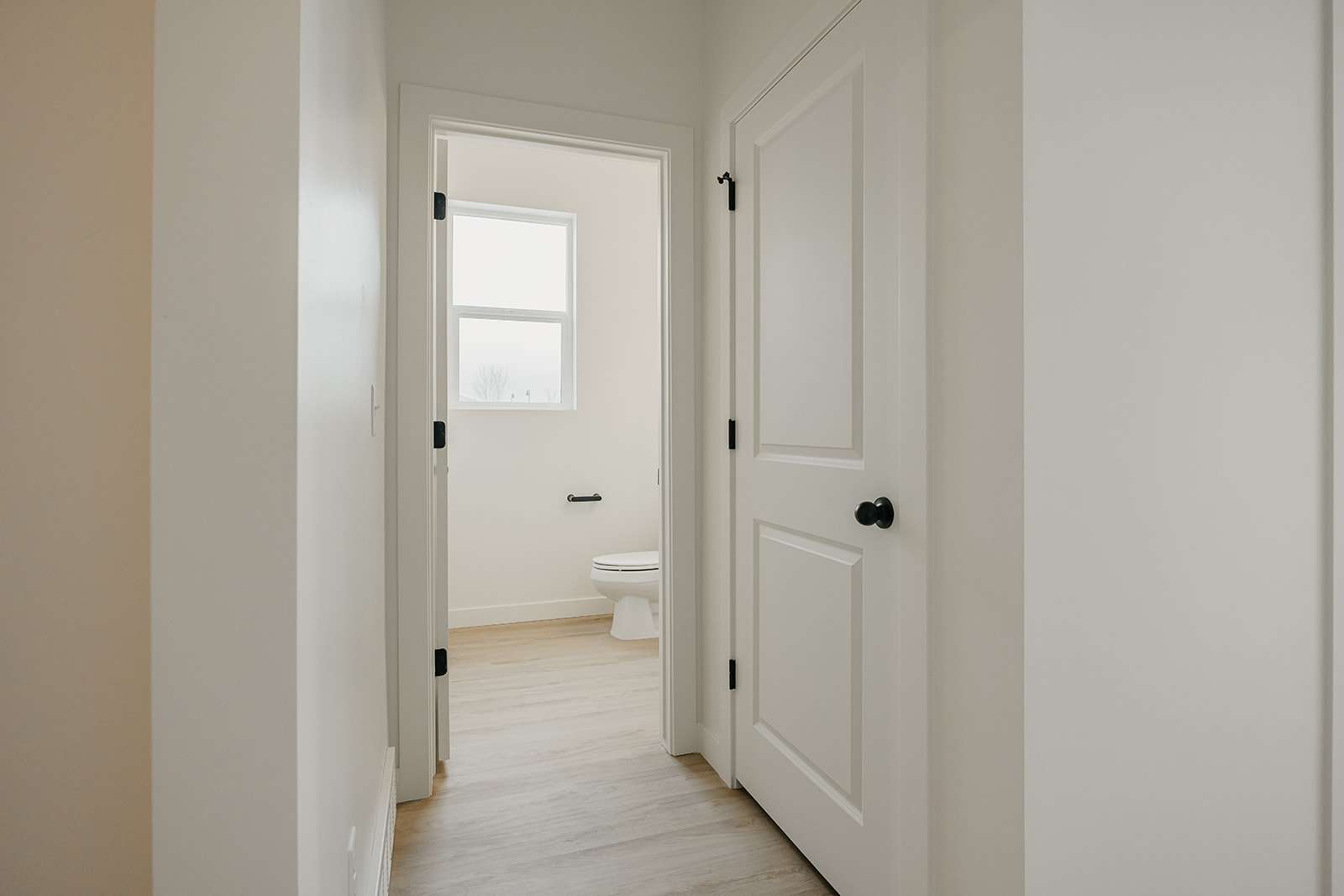 Corridor with light wood-type flooring and baseboards