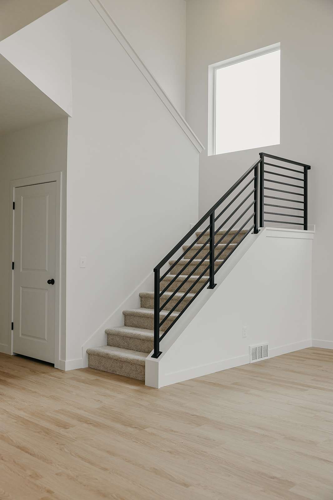 Stairs with wood finished floors and a high ceiling