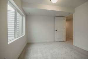 Spare room with light carpet and baseboards