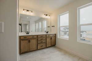 Bathroom with double vanity and light tile patterned floors