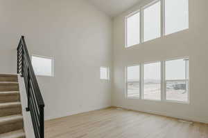 Spare room with light wood-style floors and a high ceiling