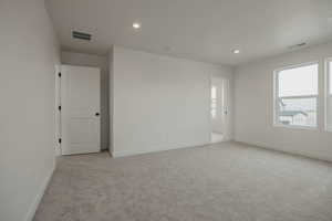 Unfurnished room with recessed lighting and light carpet
