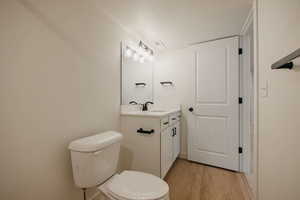 Half bathroom with vanity and light wood-style flooring