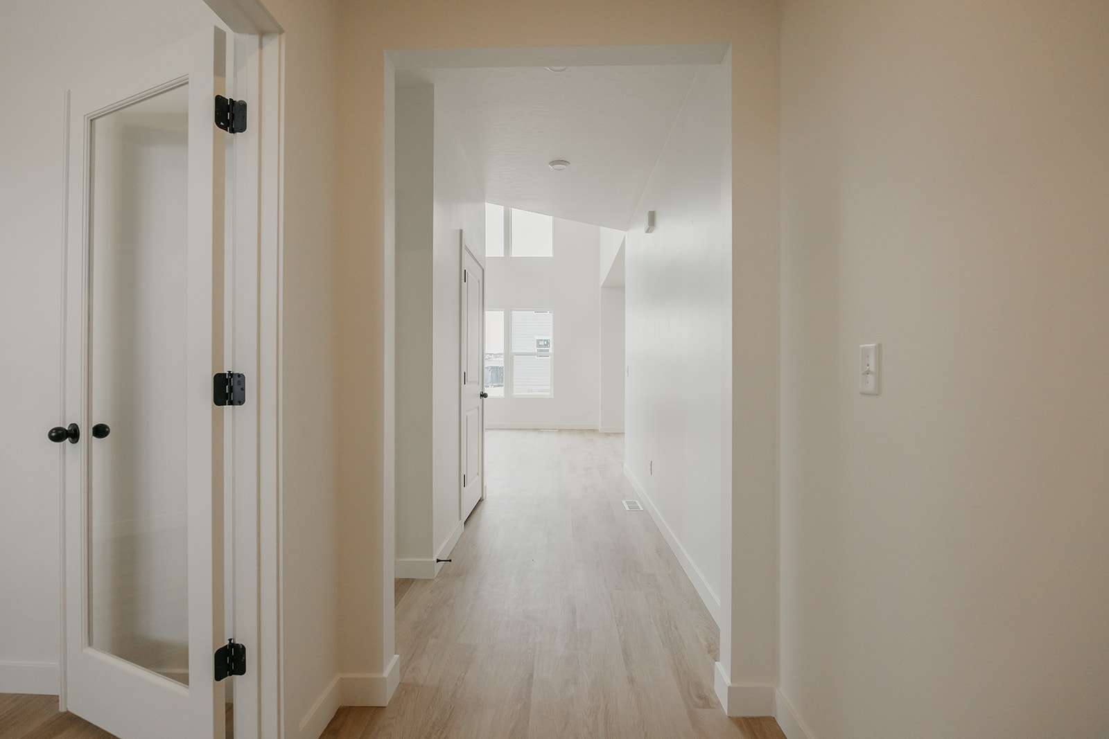 Corridor with light wood-type flooring and baseboards