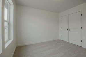 Unfurnished bedroom with carpet flooring and a closet