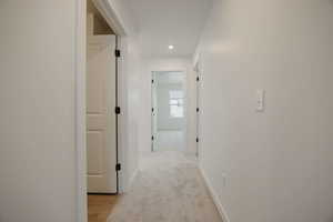 Hall with light colored carpet and recessed lighting