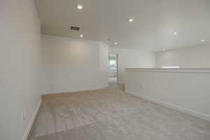 Unfurnished room with light carpet and recessed lighting