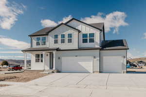 View of front of property featuring a shingled roof, a porch, board and batten siding, driveway, and a mountain view