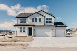 View of front of house with roof with shingles, board and batten siding, driveway, and a mountain view