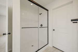 Bathroom featuring a shower stall and recessed lighting