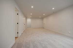 Empty room with recessed lighting and light carpet