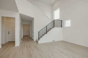 Foyer featuring a high ceiling and light wood-style flooring