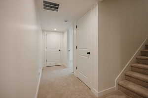 Hall featuring stairs and light colored carpet