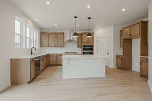 Kitchen with a center island, pendant lighting, light wood-style floors, and wood finish cabinetry