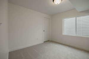 Spare room with light carpet and baseboards