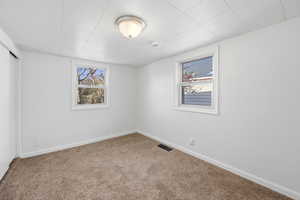 Carpeted empty room featuring baseboards