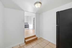 Hall with arched walkways and light tile patterned floors