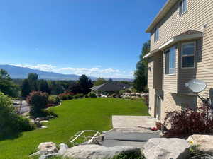 View of green lawn featuring a mountain view