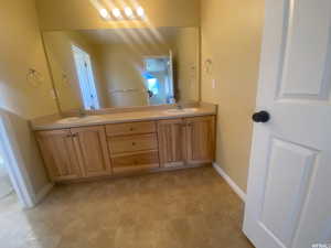 Full bath with double vanity and light floors