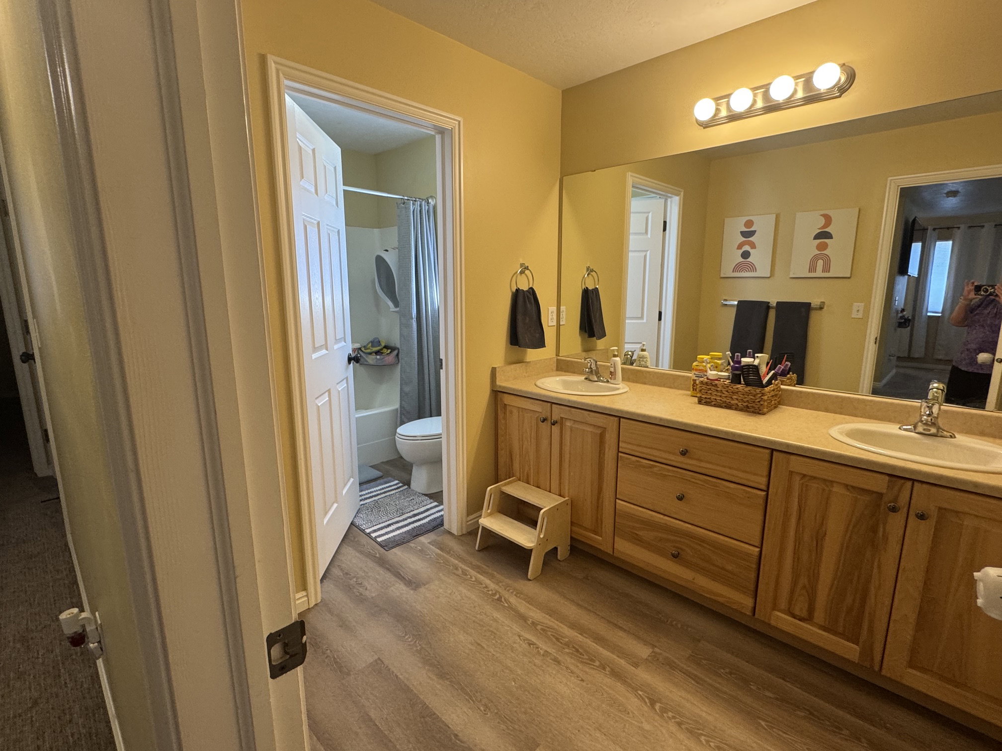 Dual basin vanity with wood-finish cabinetry and light-toned countertops