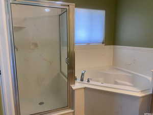 Full bath featuring a marble finish shower and a garden tub