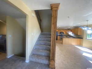 Stairway with hanging lights and tile patterned floors