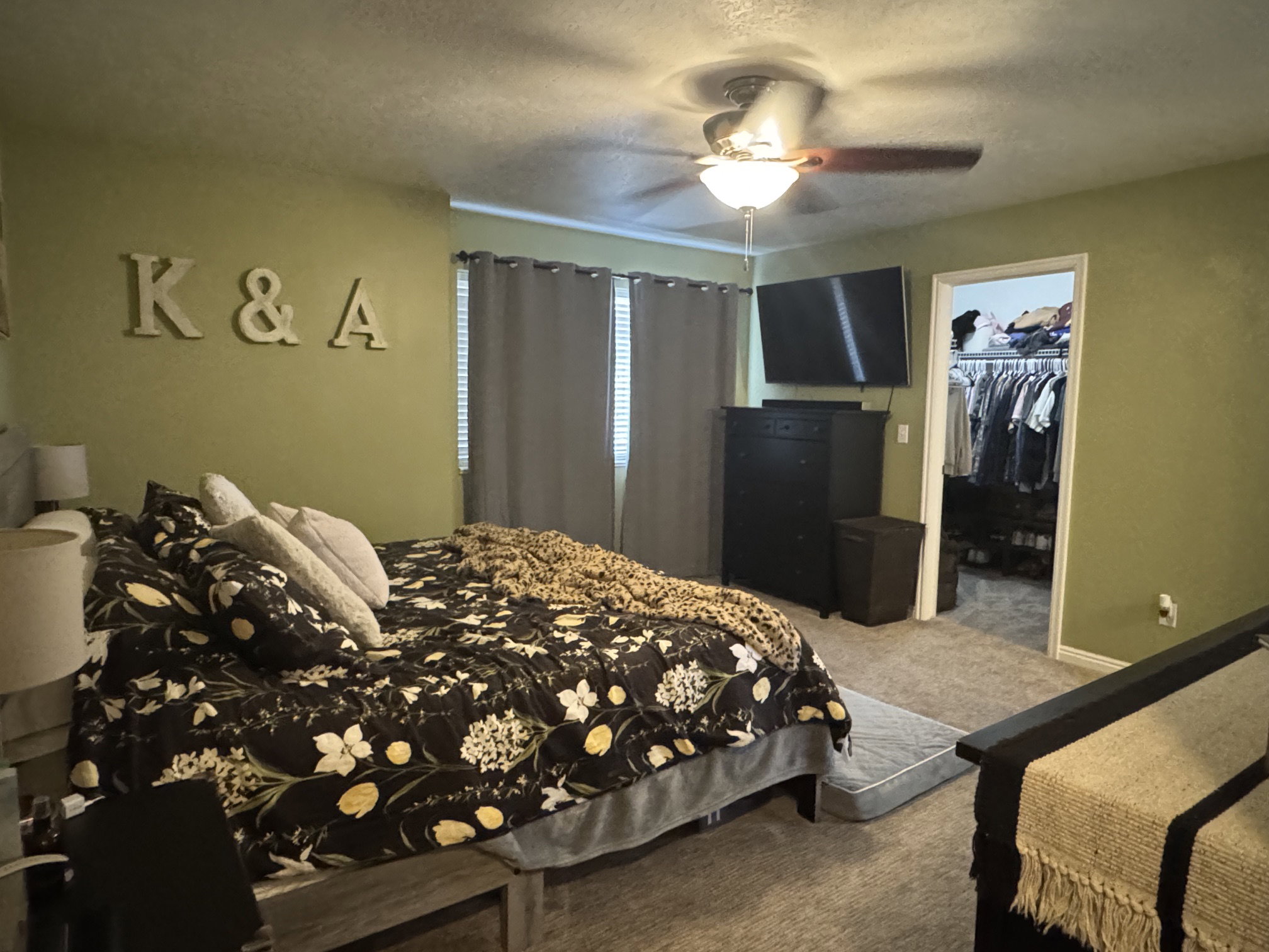 Carpeted room featuring a ceiling fan with integrated lighting, a recessed window with blinds, and a built-in closet with shelving and hanging rods