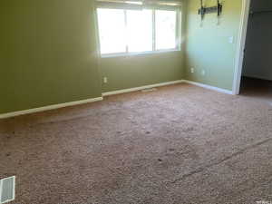 Unfurnished bedroom with a walk in closet and carpet