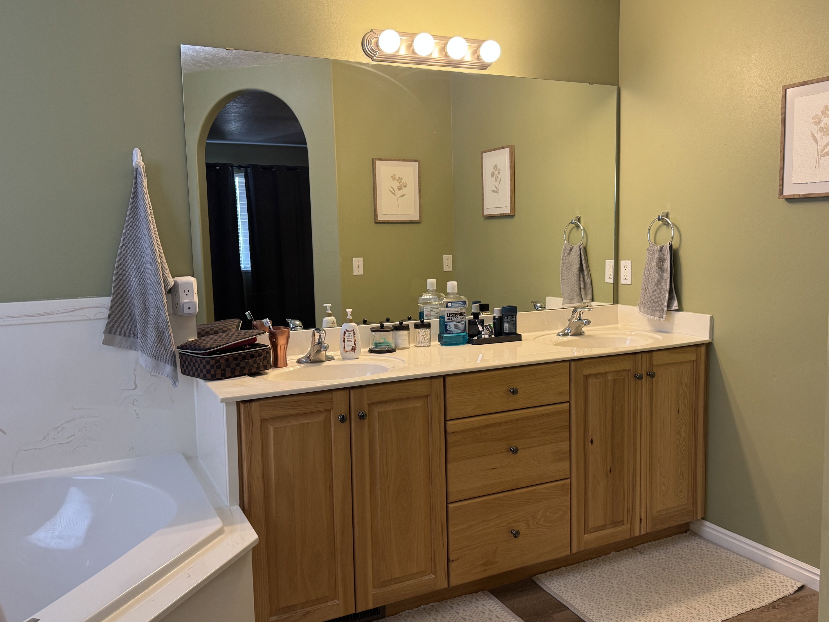Double vanity featuring wood-finish cabinetry and a light-toned countertop