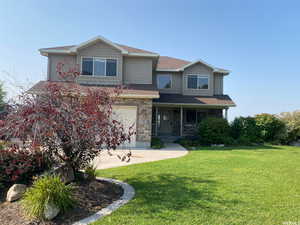 Craftsman house with a front yard, roof with shingles, covered porch, and stone siding