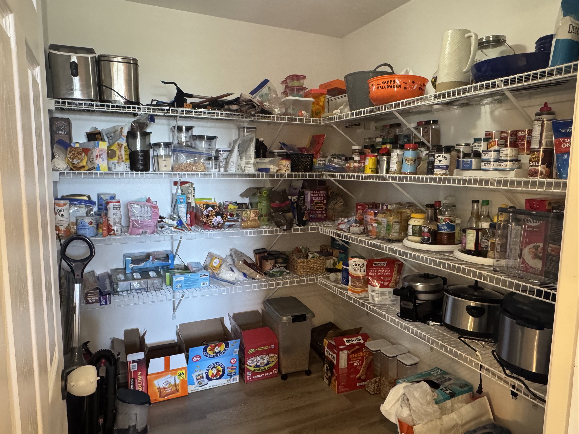 Spacious pantry featuring wire shelving, wood-finish flooring, and a white door frame