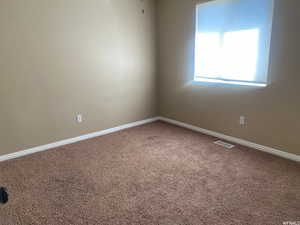 Spare room with carpet and baseboards