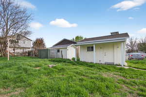 Rear view of property with a storage shed, roof with shingles, and board and batten siding